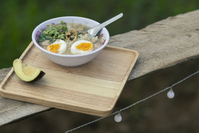 Porridge in a serving bowl with avocado on a wooden tray looks beautiful. breakfast 