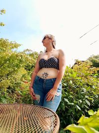 Young woman looking away against plants