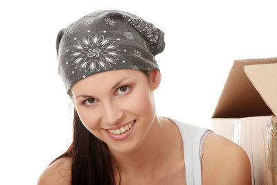 Portrait of smiling young woman against white background