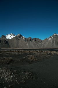 Scenic view of snowcapped mountains against clear blue sky