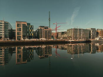 Reflection of buildings in lake against sky