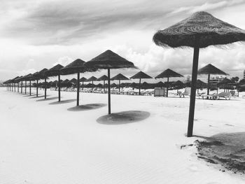 Parasols at beach against sky