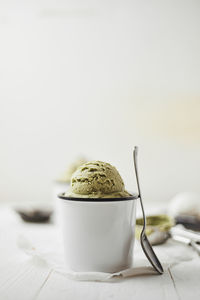 Close-up of ice cream on table against white background