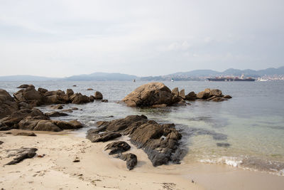 Rocks on beach against sky