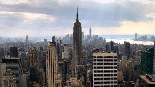 Modern buildings in city against cloudy sky