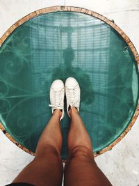 Low section of person standing by swimming pool