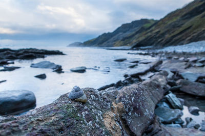 Rocks by sea against sky