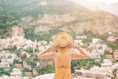 Rear view of woman standing against cityscape