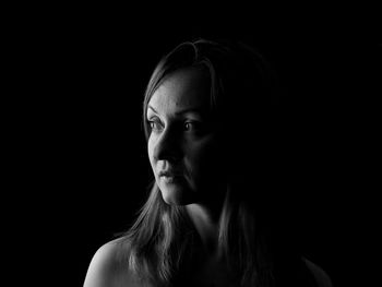 Portrait of woman against black background