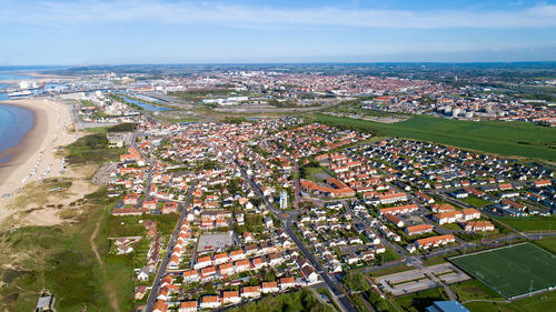 High angle view of buildings by sea against sky