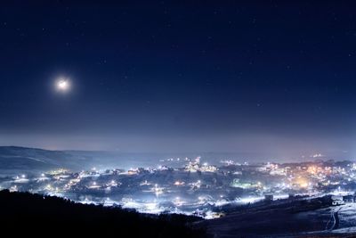 Illuminated city against sky at night