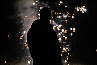 Rear view of silhouette man standing at night