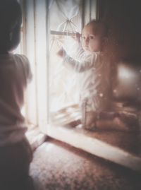 Baby boy by window at home