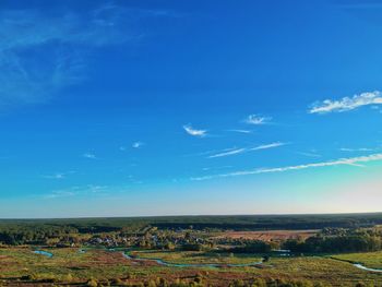 Scenic view of field against blue sky