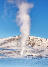 Scenic view of volcanic mountain against blue sky