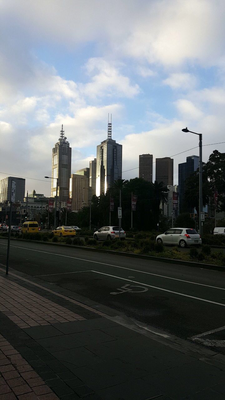 VIEW OF CITY STREET AND BUILDINGS AGAINST SKY IN BACKGROUND