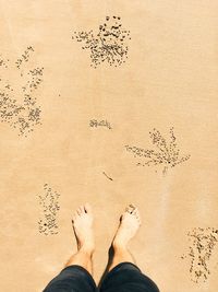 Low section of man standing on sand
