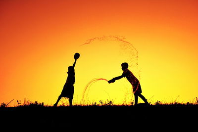 Silhouette of children playing at sunset