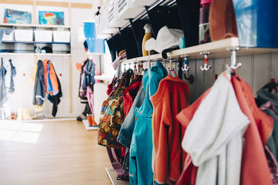 Various clothes hanging from hooks in cloakroom at preschool