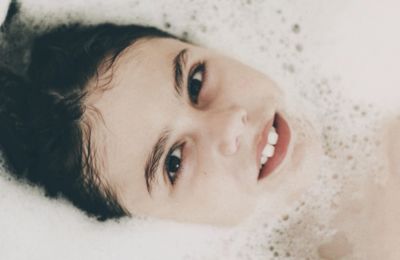 Close-up portrait of girl taking a bath