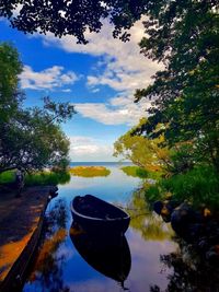 Boat moored in lake against sky