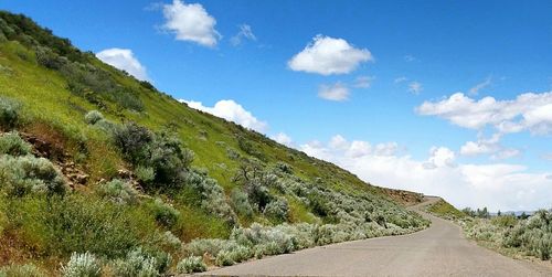 Country road against cloudy sky