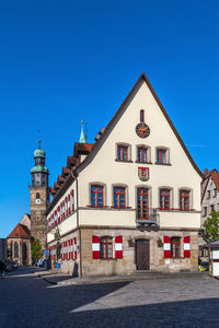 Buildings in city against clear blue sky