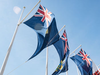 Low angle view of flags against blue sky