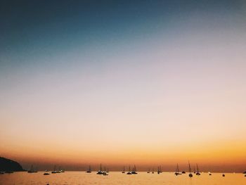 View of boats in the sea at sunset