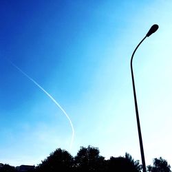 Low angle view of vapor trail against blue sky