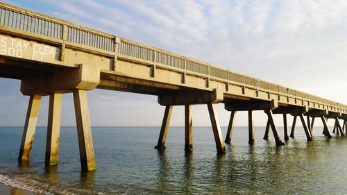 Low angle view of bridge over sea against sky