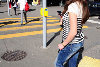 Woman with smart phone walking on street