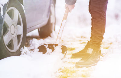 Low section of man removing snow from road