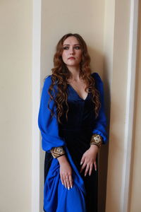 Teenage girl wearing royal blue dress standing at home