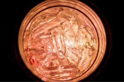 Close-up of illuminated electric lamp against black background