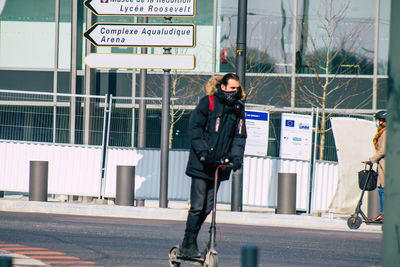 Full length of woman standing on road in city