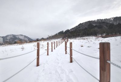 Scenic view of snow covered field against sky