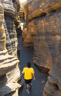 Rear view of man walking in cave