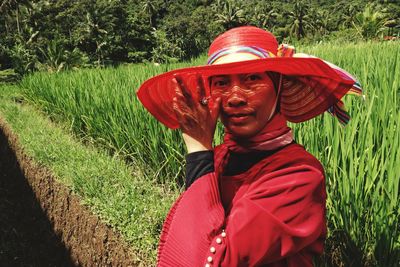 Rear view of woman wearing hat standing on field