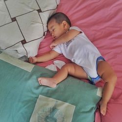 High angle view of baby sleeping on bed