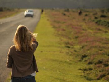 Rear view of woman standing on field