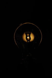 Close-up of illuminated lamp against black background
