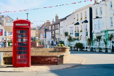Buildings by street in city against sky