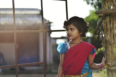 Close-up of young woman standing against window