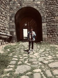 Full length of woman standing against building