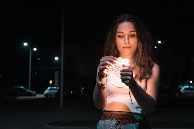 Portrait of beautiful woman standing at night