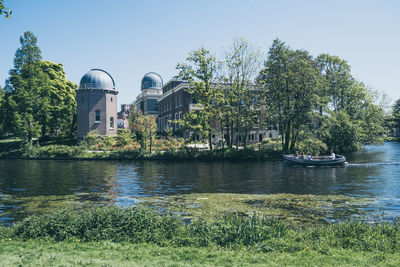 River by buildings against clear sky