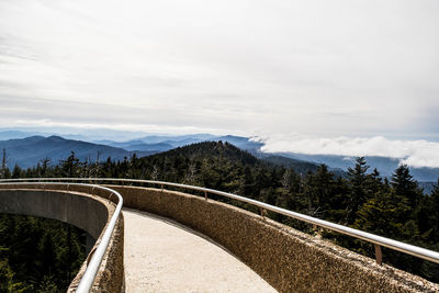 Road leading towards mountains against sky