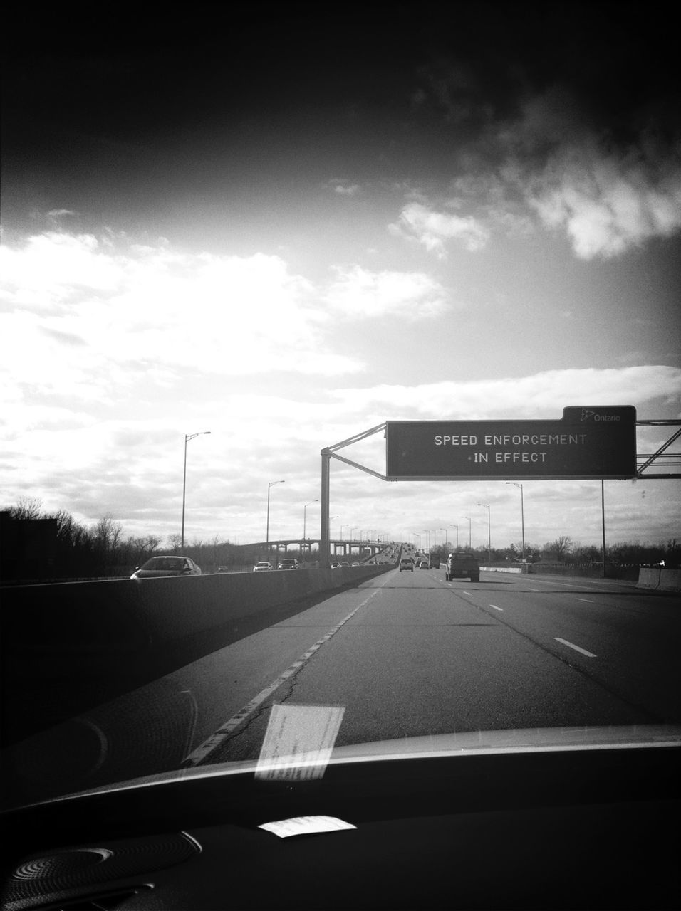 transportation, car, mode of transport, road, land vehicle, road marking, sky, cloud - sky, the way forward, road sign, windshield, on the move, street, travel, arrow symbol, highway, text, cloud, communication, tree