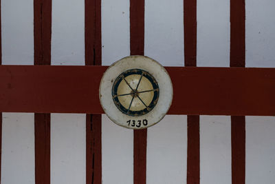 Close-up of information sign on wood against wall